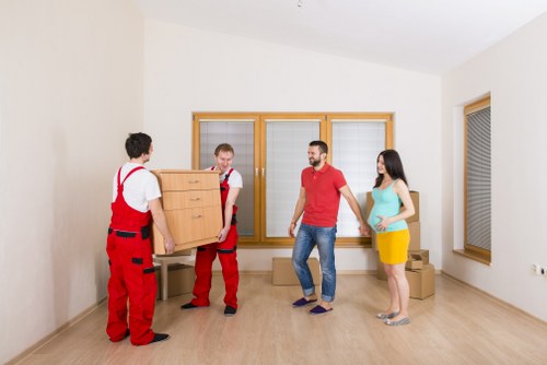 Removal team loading furniture carefully outside an Enfield property