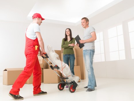 Office movers handling desks, boxes, and furniture during an Enfield relocation